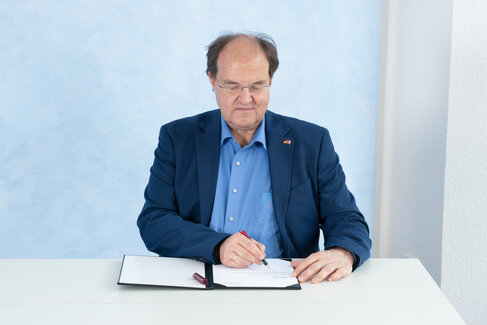 Rektor Ludwig Holtmeier beim Unterschreiben der Urkunde
