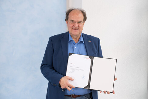 Rektor Ludwig Holtmeier mit Urkunde in der Hand