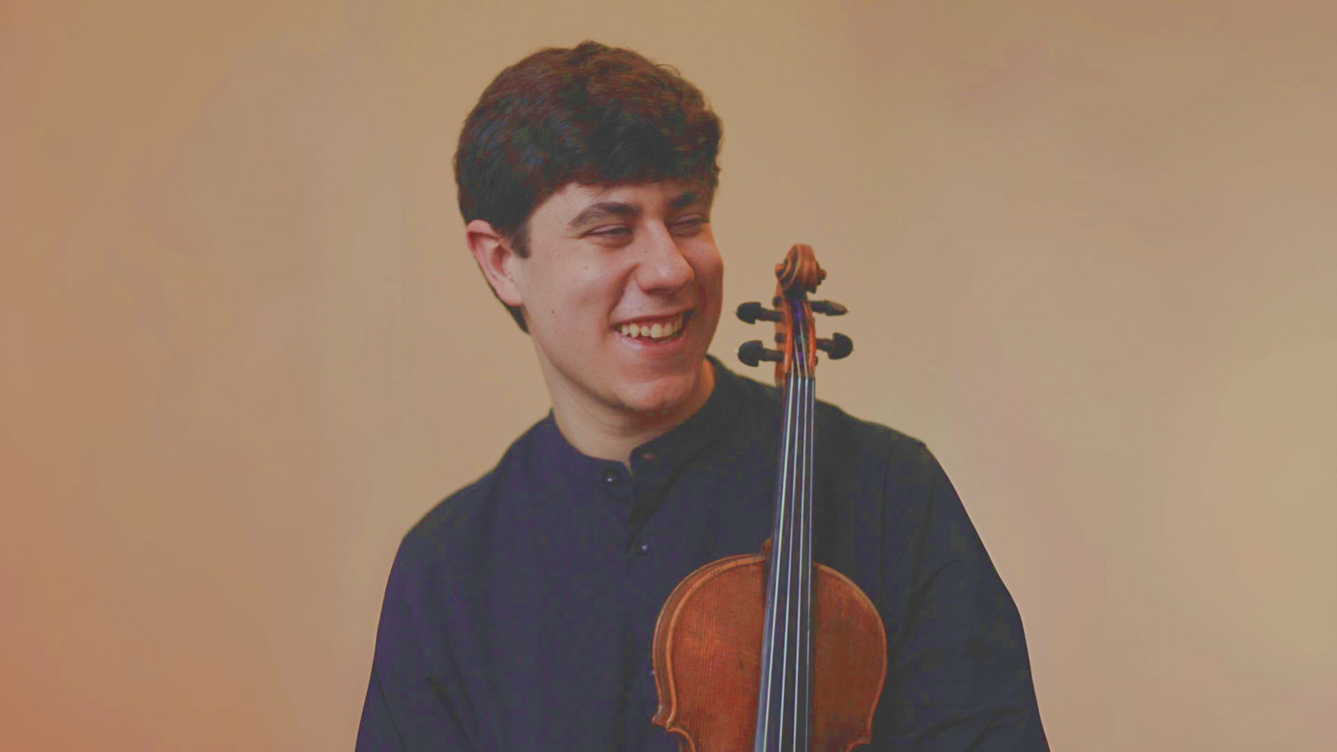 Raúl González García im schwarzen Hemd mit Geige in der Hand